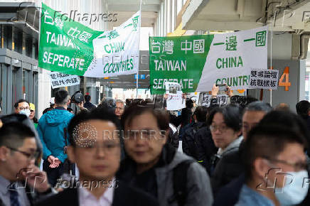 Protesters holding flags supporting Taiwan's independence stand outside the Songshan Airport while Shanghai Vice Mayor Hua Yuan arrives for the annual city forum in Taipei