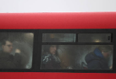 Commuters sit on a bus as it rains during the morning rush-hour in London