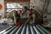 Ukrainian servicemen prepare rockets for a Grad MLRS near a front line in Donetsk region