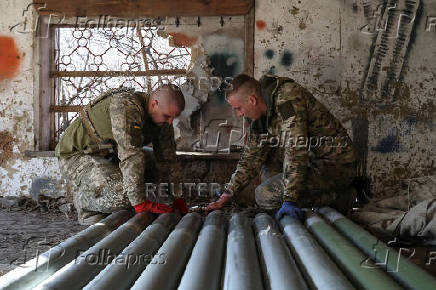 Ukrainian servicemen prepare rockets for a Grad MLRS near a front line in Donetsk region