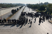 Security force personnel guard a road to prevent an anti-government rally in Islamabad