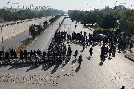 Security force personnel guard a road to prevent an anti-government rally in Islamabad