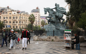 People walk along a street, in Damascus