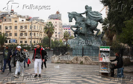 People walk along a street, in Damascus