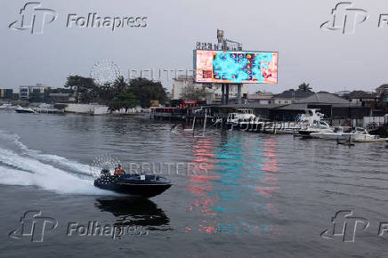 A man sails a boat on a lagoon near the Lekki-Ikoyi Link Bridge in Lagos