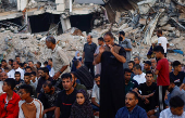 Palestinians hold Eid al-Adha prayers by the ruins of the Al-Rahma mosque destroyed by Israeli air strikes, in Khan Younis, in the southern Gaza strip