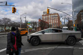 People are taken for a test drive in a Tesla Cybertruck near a Tesla showroom in New York City