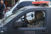 Policiais militares mascarados em viatura durante operao na favela da Rocinha