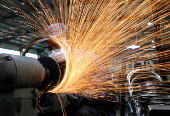 FILE PHOTO: Worker wearing a face mask works on a production line manufacturing bicycle steel rim at a factory in Hangzhou, Zhejiang