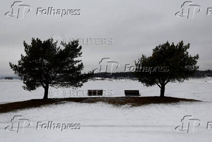 Empty benches overlook icy water at Storoyodden beach in Fornebu, outside Oslo