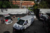 Carros de servio funerrio deixam a escola de Suzano (SP) aps o ataque