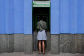 FILE PHOTO: A woman uses a PrivatBank ATM machine in Kyiv