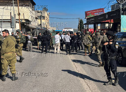 Israeli security and rescue personnel at the scene of a shooting attack on a car and bus where at least three Israelis were killed near Kedumim in the Israeli-occupied West Bank