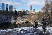 A person poses for photographs in Central Park, in New York