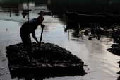 Homem trabalha no rio Capibaribe