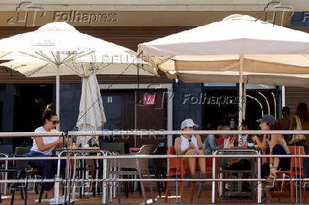 Tourists sit on a terrace next to the vacation housing building in Las Palmas de Gran Canaria
