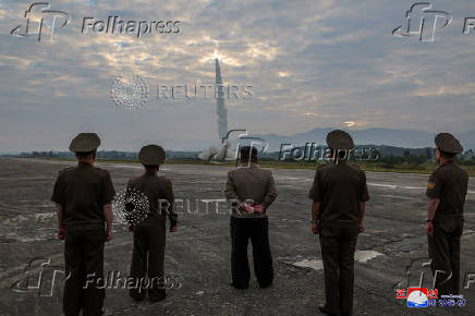 North Korean leader Kim Jong-un looks on during the test of what KCNA described as a new tactical ballistic missile