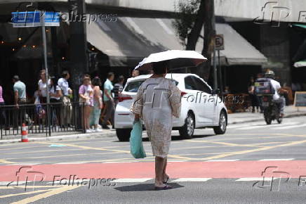 Forte calor faz pedestres se protegerem do sol