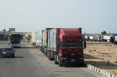 Aid trucks wait near the Rafah border crossing between Egypt and the Gaza Strip