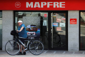 A man walks past an office of Spain's insurance company Mapfre, in Ronda
