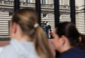 Tourists stand near Buckingham palace in London