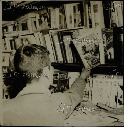 Garoto pega livro de prateleira em livraria, na cidade de So Paulo (1950)