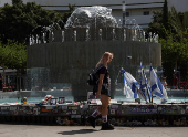 A woman walks past memorabilia and pictures of the hostages kidnapped in the deadly October 7 attack on Israel by the Palestinian Islamist group Hamas from Gaza, at Dizengoff Square, in Tel Aviv