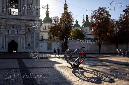 People walk near a memorial to fallen Ukrainian service members in St Sophia Square in central Kyiv