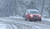 A car drives through the snow in Aviemore, Scotland