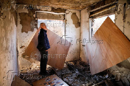 People inspect the damage caused by projectiles fired from Lebanon, following the ceasefire between Israel and Iran-backed group Hezbollah, in Metula