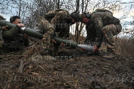 Policemen of the 'Khyzhak' Brigade extract a shell from a mortar during fire towards Russian troops at their position in a front line near the town of Toretsk