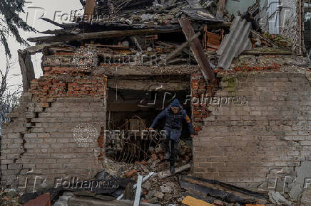 Mykola searchers for firewood in a building damaged by Russian military strikes in Pokrovsk