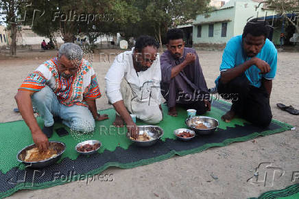 Displaced Sudanese break their fast at a displacement camp during the month of Ramadan, in the city of Port Sudan