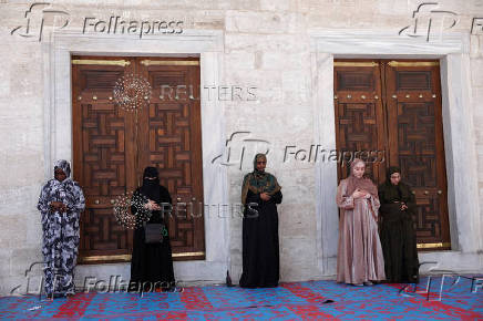 Women attend the Friday prayers at the courtyard of the Blue Mosque in Istanbul