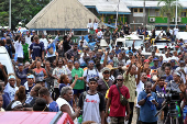 Supporters of former Prime Minister Gordon Darcy Lilo cheer and wave at a rally ahead of the election in the capital Honiara