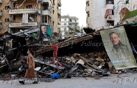 A woman walks past the rubble of a building in Beirut