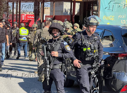 Israeli security and rescue personnel at the scene of a shooting attack on a car and bus where at least three Israelis were killed near Kedumim in the Israeli-occupied West Bank