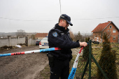 A police officer ties a barricade tape at the site of a damaged nursing home that caught fire, outside Belgrade