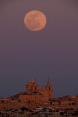 The full moon, also known as the Pink moon, rises behind St Paul's Metropolitan Cathedral in the medieval city of Mdina