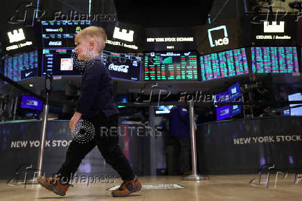 Traders and kids work on the floor of the NYSE in New York