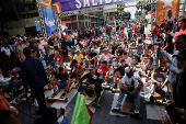 Government supporters participate in a traditional street race with wooden makeshift carts called 