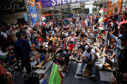 Government supporters participate in a traditional street race with wooden makeshift carts called 