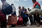 Venezuelans queue to enter a shelter after leaving Venezuela, in Pacaraima