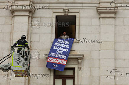 Far-right political party Chega expose banners on the facade of the Portuguese parliament against the wage reinstatement for politicians after the cuts imposed by the Troika, during the debate and vote of the 2025 budget bill on final reading, in Lisbon