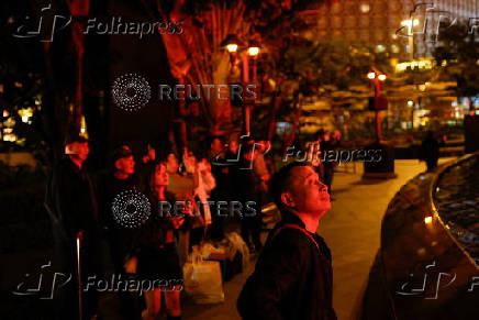 Visitors watch water fountain show outside the Wynn Macau casino resort ahead of the 25th anniversary of Macau's handover, in Macau