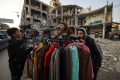 Firas, 15, a street vendor  jokes with his friends at the street market, in Douma