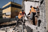 Trabalhadores da construo civil removem escombros de edifcio bombardeado