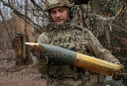FILE PHOTO: A serviceman of the National Guard of Ukraine prepares a shell for a howitzer at a position in a front line in Donetsk region