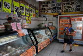 A woman carries a package of meat in a butcher's shop, in Monterrey