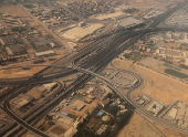 An aerial view shows bridges and new roads with Cairo's traffic, and the Adly Mansour Transportation Hub and interchange station